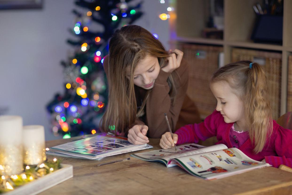 children browsing christmas toy catalogue