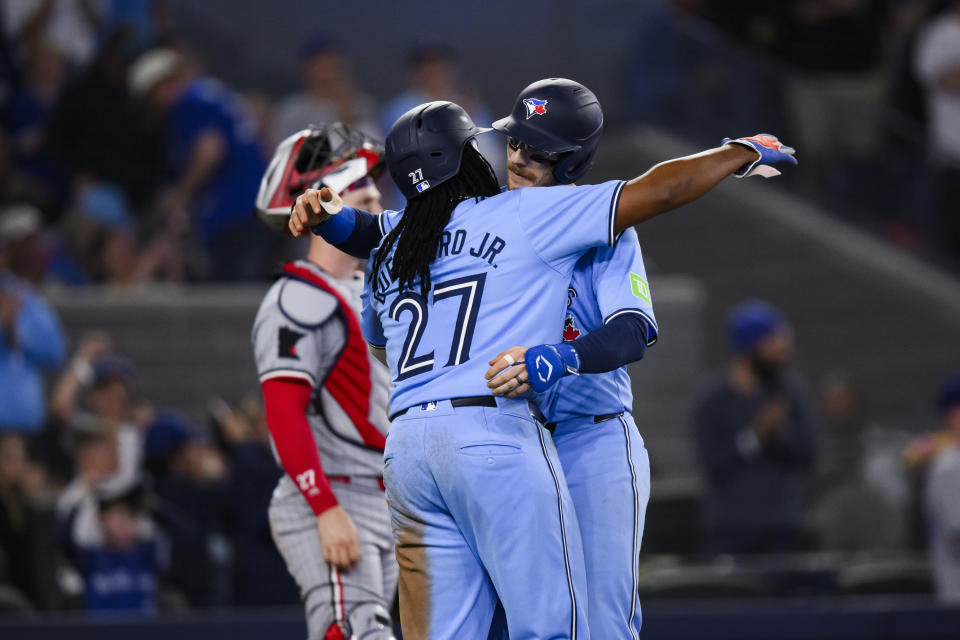 Toronto Blue Jays' Danny Jansen (9) celebrates with Vladimir Guerrero Jr. (27) after they both scored on Jansen's two-run home run during the fifth inning of a baseball against the Minnesota Twins, Saturday, May 11, 2024, in Toronto. (Chris Katsarov/The Canadian Press via AP)