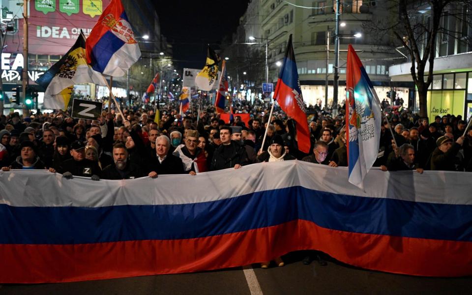 People wave Russian and Serbian flags during a rally organised by Serbian nationalist groups - Andrej ISAKOVIC / AFP