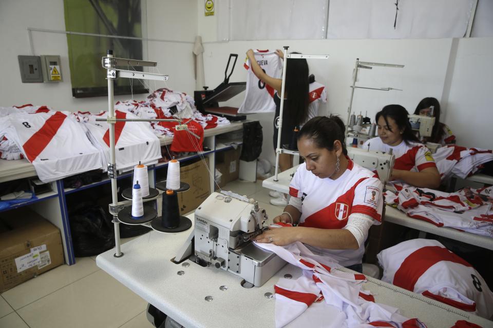 Mujeres fabrican camisetas de la selección de fútbol de Perú en el mercado Gamarra, uno de los mercados de textiles más grandes de Latinoamérica, el miércoles, 8 de noviembre de 2017, en Lima. (AP Foto/Martin Mejia)