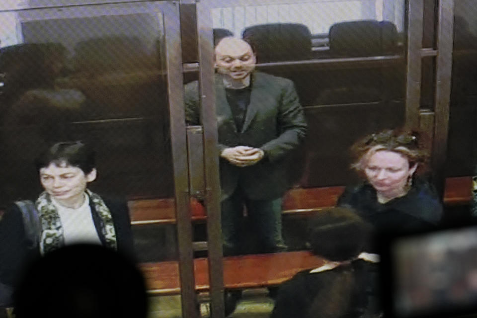 Vladimir Kara-Murza is seen on a TV screen as he stands in glass cage as he listens to the verdict in a courtroom at the Moscow City Court in Moscow, Russia, on Monday, April 17, 2023. A top Kremlin foe was convicted Monday on charges of treason and denigrating the Russian military and sentenced him to 25 years in prison after a trial that marked the latest move in a relentless crackdown on the opposition amid the fighting in Ukraine. (AP Photo/Alexander Zemlianichenko)