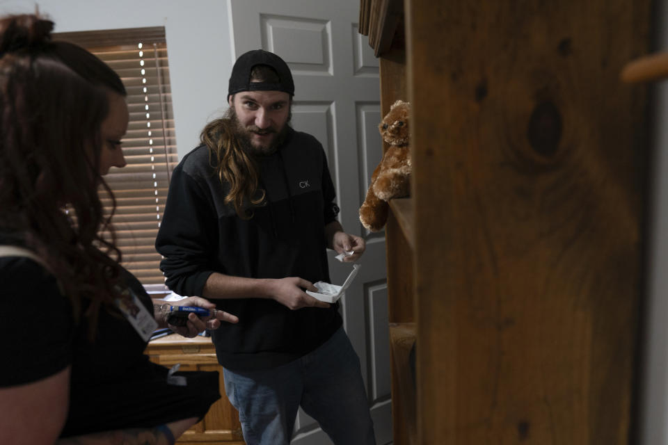 Tyler Baker retrieves fentanyl from his bedroom closet for disposal as his peer support worker Jesse Johnson of the Family Resource Center looks on at left, in Findlay, Ohio, Thursday, Oct. 12, 2023. They flushed the fentanyl. The powerful lab-produced opioid has driven the number of fatal drug overdoses in the U.S. to record levels. (AP Photo/Carolyn Kaster)