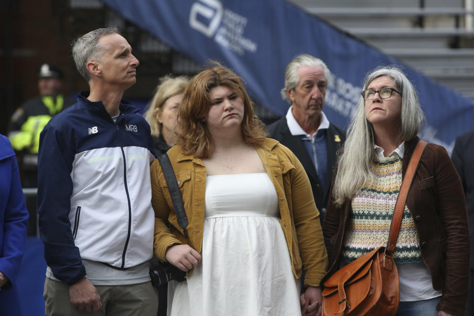 The family bombing victim Martin Richards, from left, Bill, father, Jane, sister, and Denise, mother, participate in a moment of silence during a gathering at a memorial for victims of the 2013 Boston Marathon bombing, Saturday April 15, 2023, in Boston. (AP Photo/Reba Saldanha)