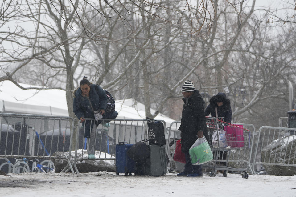 FILE - People hop a fence to get to a footbridge to Manhattan at a temporary shelter for migrants on Randall's Island in New York, Friday, Jan. 19, 2024. As New York City struggles to house an influx of immigrants, an unsanctioned tent community is growing outside the gates of the city's largest migrant shelter on Randall’s Island. New immigrants trying to earn a living have also set up a makeshift bazaar to sell coffee, snacks and other items. (AP Photo/Seth Wenig, File)