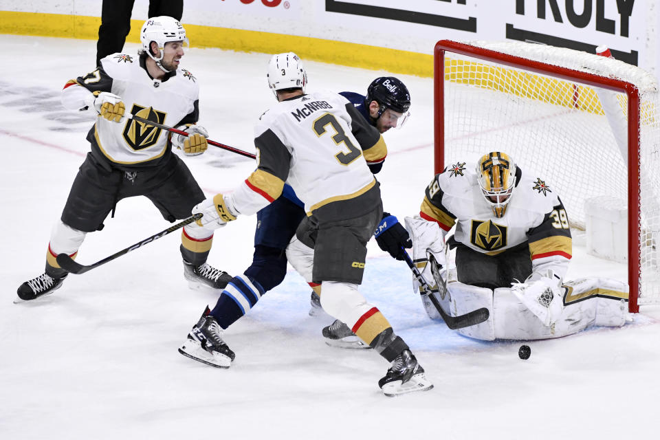 Vegas Golden Knights' goaltender Laurent Brossoit (39) makes a save against Winnipeg Jets' Dylan Demelo (2) as Golden Knights' Brayden McNabb (3) and Shea Theodore (27) defend during second-period Game 4 NHL Stanley Cup first-round hockey playoff action in Winnipeg, Manitoba, Monday April 24, 2023. (Fred Greenslade/The Canadian Press via AP)