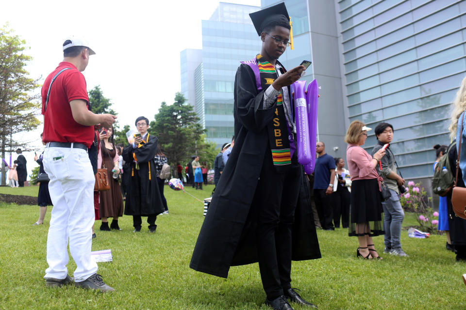 Richard Nicholls, 22, a graduate in engineering from The City College of New York is on his phone after his commencement ceremony in Manhattan on May 31, 2019. When asked about the issues he is most concerned about leading up to the 2020 election, he said, 