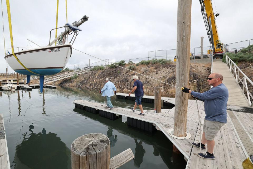 Sailboats are hoisted back into the Great Salt Lake marina in Salt Lake City on Tuesday. Water levels have raised enough for sailing on the lake.