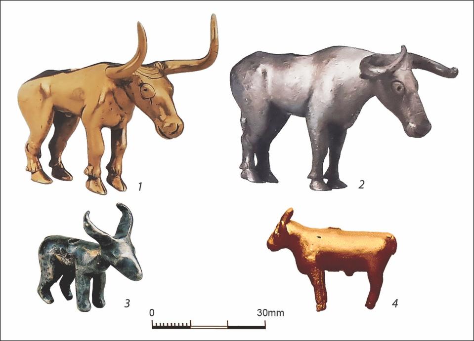 four silver and gold bull figurines