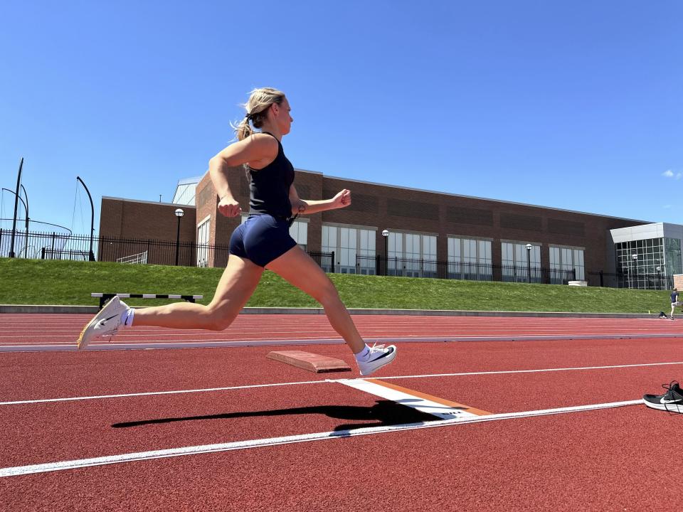 Michigan junior Riley Ammenhauser practices on a track, Tuesday, April 30, 2024 in Ann Arbor, Mich. Ammenhauser has become a record-breaking, triple-jumping track athlete and something of an entrepreneur. Leveraging her value with about 250,000 followers on social media, she has landed endorsement deals with Peloton, Gatorade and Lululemon while potentially setting herself up with a career as an influencer after hanging up her spikes. (AP Photo/Larry Lage)