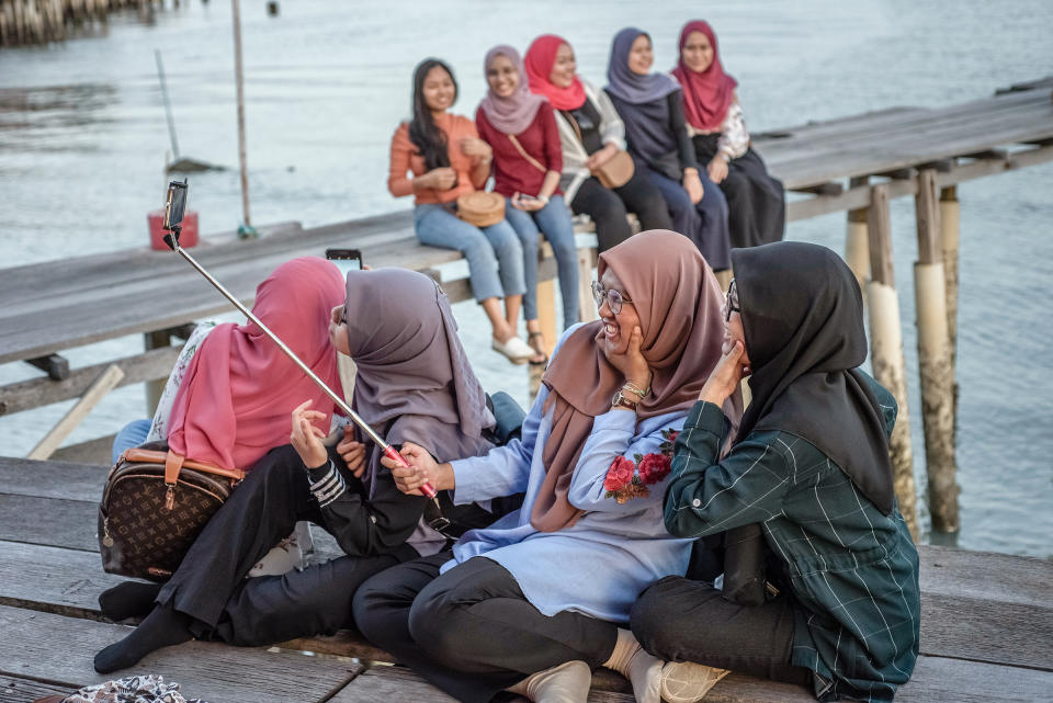 Muslim women enjoy the sunset in one of the Clan Jetties villages, in George Town, Penang Island, Malaysia, in January 2019. | Oleksandr Rupeta—NurPhoto via Getty Images