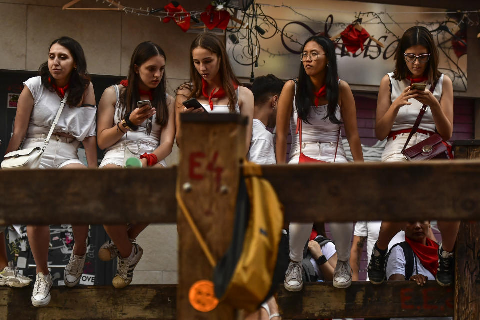 A group of youths wait for the start of the last "encierro" or running of the bulls during the San Fermin festival in Pamplona, northern Spain, Thursday, July 14, 2022. (AP Photo/Alvaro Barrientos)