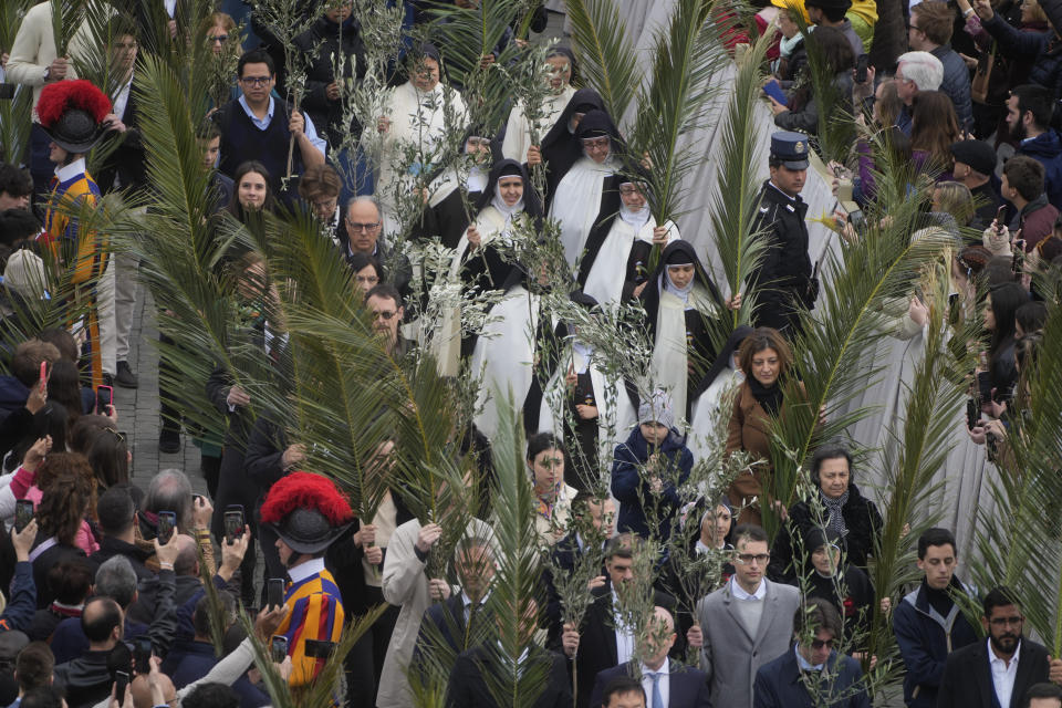 Palm bearers arrive in a procession at the start of the Palm Sunday's mass celebrated by Pope Francis in St. Peter's Square at The Vatican Sunday, April 2, 2023 a day after being discharged from the Agostino Gemelli University Hospital in Rome, where he has been treated for bronchitis, The Vatican said. The Roman Catholic Church enters Holy Week, retracing the story of the crucifixion of Jesus and his resurrection three days later on Easter Sunday. (AP Photo/Gregorio Borgia)