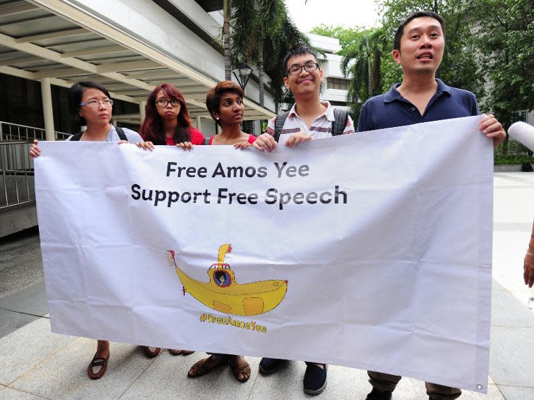 Supporters of Singapore teenage blogger Amos Yee hold up a banner outside the state court in Singapore on July 6, 2015