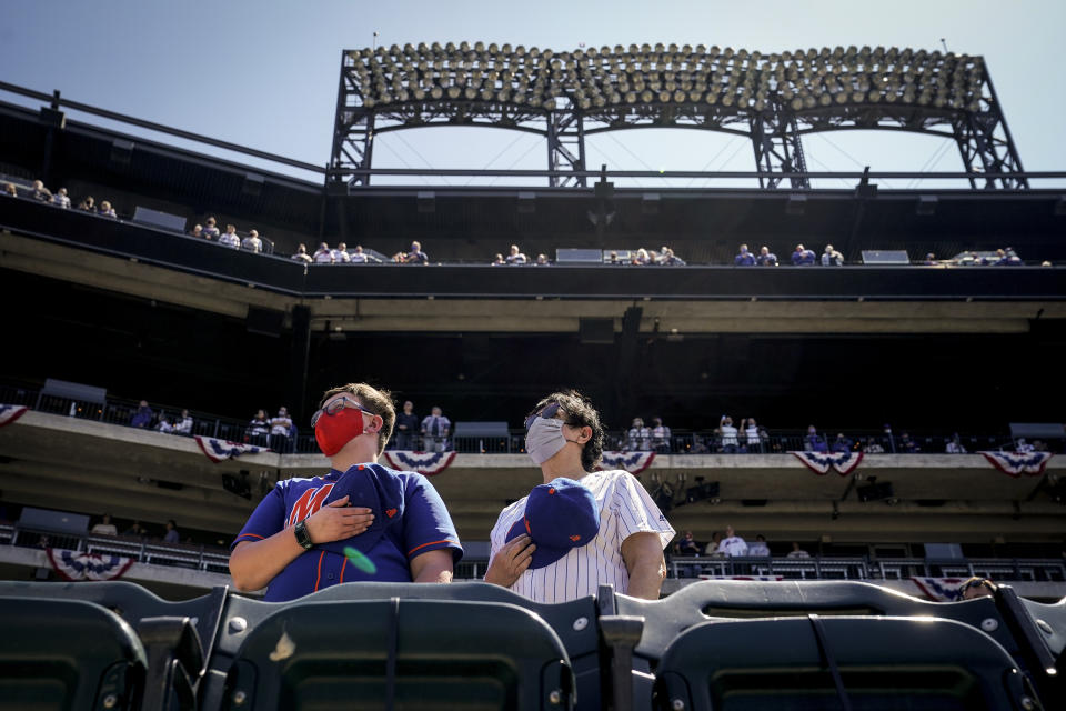 Fans stand for pre-game ceremonies before a baseball game between the New York Mets and the Miami Marlins, Thursday, April 8, 2021, in New York. (AP Photo/John Minchillo)