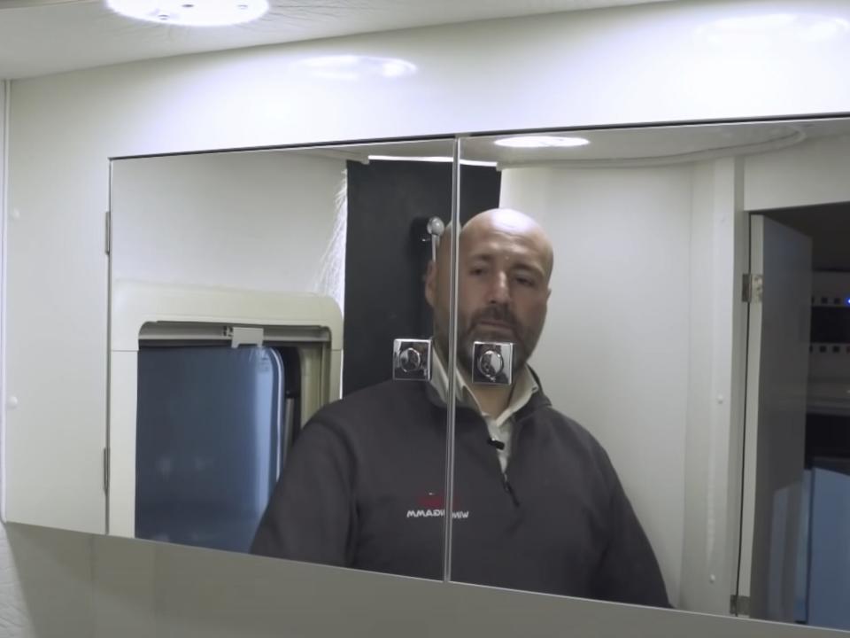 a person looking in the bathroom vanity
