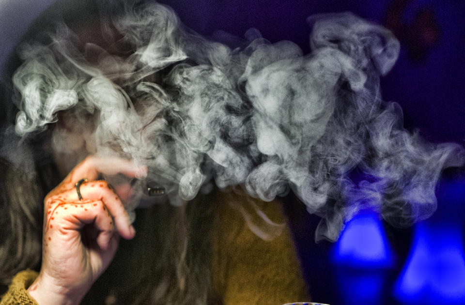 FILE - In this Saturday, Dec. 22, 2018, file photo, a guest takes a puff of a cannabis vape pen during a marijuana event in downtown Los Angeles. A short walk from police headquarters in the heart of downtown, a cluster of bustling shops are openly selling packaging and hardware that can be used to produce counterfeit, and potentially dangerous, marijuana vapes that have infected California's cannabis market and possibly sickened dozens of people. (AP Photo/Richard Vogel, File)