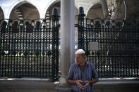 A man stands on a mosque compound in Istanbul, Wednesday, Aug. 15, 2018. The Turkish lira currency has nosedived in value in the past week over concerns about Turkey's President Recep Tayyip Erdogan's economic policies and after the United States slapped sanctions on Turkey angered by the continued detention of an American pastor. (AP Photo/Lefteris Pitarakis)