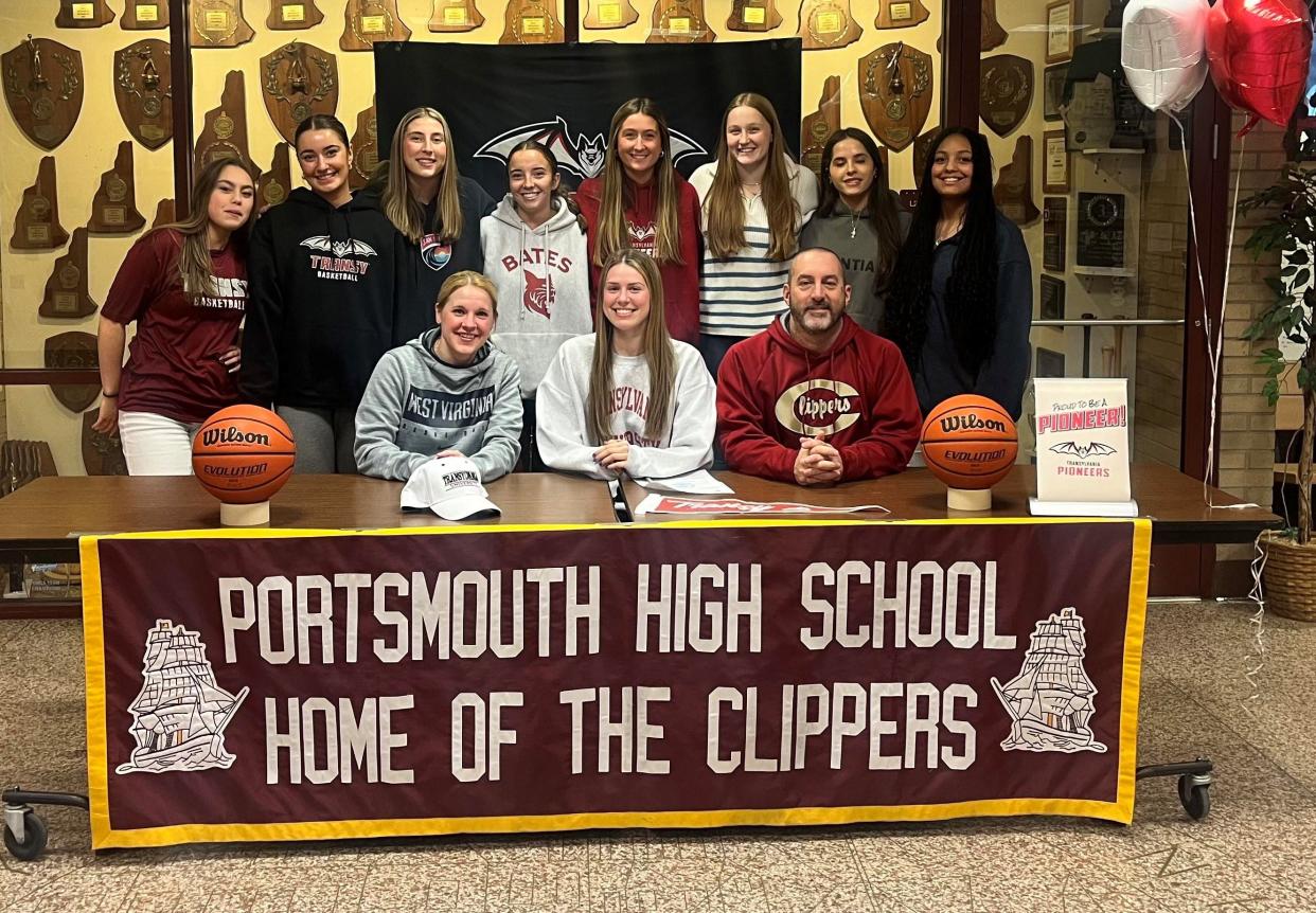 Portsmouth High School senior Mackenize Lombardi, front center, is joined by girls head basketball coach Tim Hopley, assistant coach Anne Hakey, and her teammates after announcing she will continue her academic and athletic careers next year at Transylvania University.