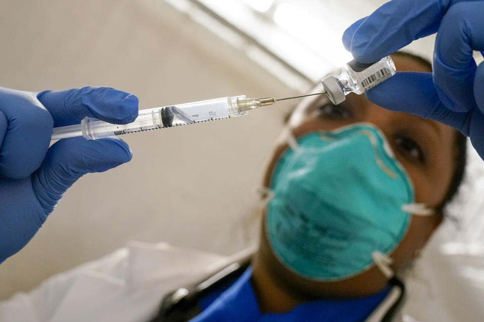 FILE - In this Jan. 15, 2021, file photo, Dr. Yomaris Pena, Internal Medicine Physician with Somos Community Care at a COVID-19 extracts the last bit of Pfizer COVID-19 vaccine out of a vial so as not to waste it at a vaccination site at the Corsi Houses in the East Harlem neighborhood of New York. The number of COVID-19 vaccinations is falling in the U.S. And some experts worry that the decision to give booster doses could end up hurting efforts to get the unvaccinated to take shots at all. (AP Photo/Mary Altaffer, File)