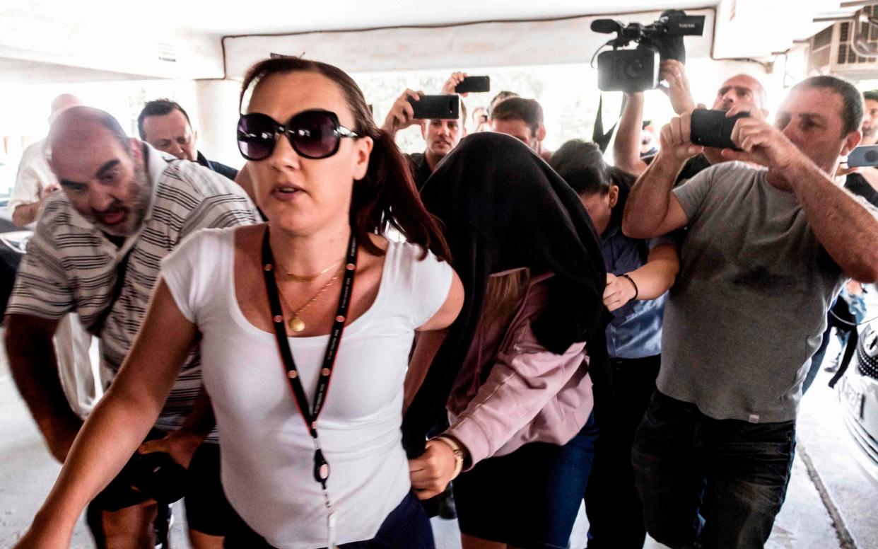 The British woman is led into a courthouse in Paralimni, Cyprus - AFP