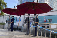 Chinese security guards stand behind shields on duty outside the Evergrande headquarters in Shenzhen, China, Friday, Sept. 24, 2021. Things appeared quiet at the headquarters of the heavily indebted Chinese real estate developer Evergrande, one day after the day it had promised to pay interest due to bondholders in China. (AP Photo/Ng Han Guan)