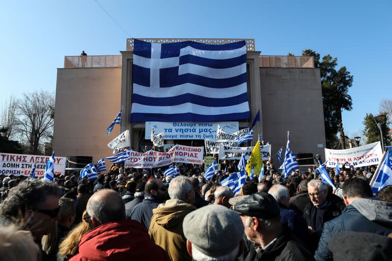 A giant Greek flag hangs on the municipal theatre of the city of Mytilene as locals take part in a protest against overcrowded migrants camps on the island of Lesbos