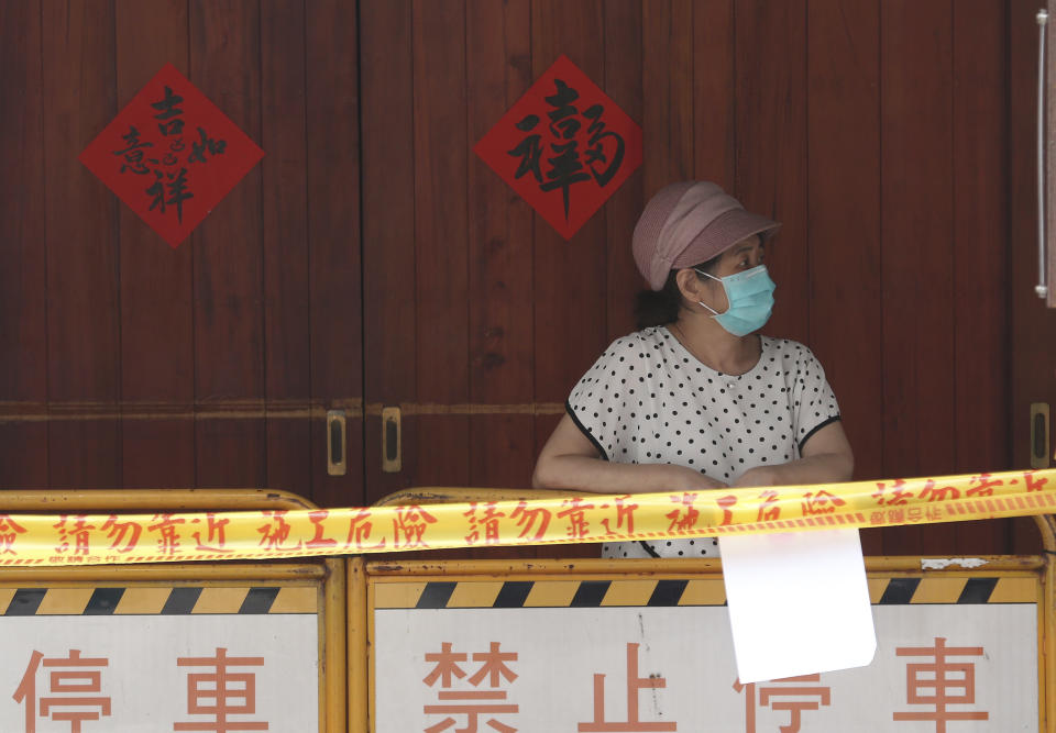 A woman wearing face masks to protect against the spread of the coronavirus lines up at a rapid coronavirus testing center after the COVID-19 alert raise to level 3 in Taipei, Taiwan, Tuesday, May 18, 2021. (AP Photo/Chiang Ying-ying)