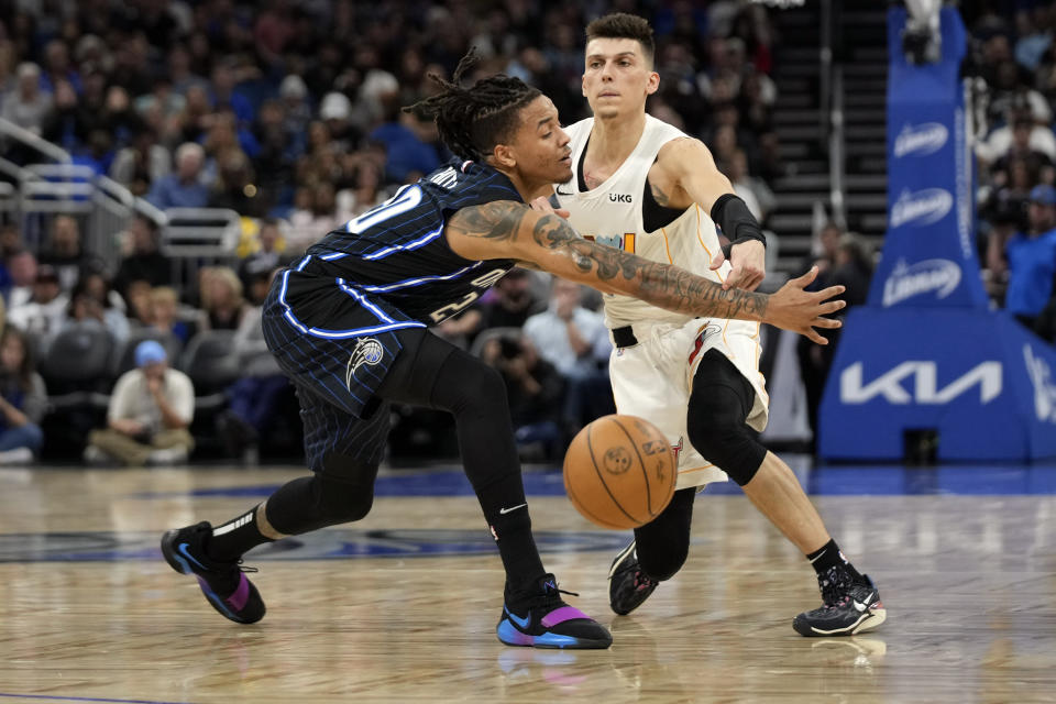 Miami Heat guard Tyler Herro, right, passes the ball past Orlando Magic guard Markelle Fultz during the first half of an NBA basketball game, Saturday, Feb. 11, 2023, in Orlando, Fla. (AP Photo/John Raoux)