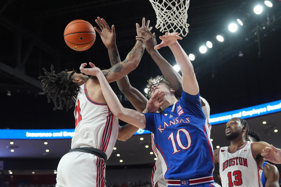 Kansas' Johnny Furphy (10) and Houston's Emanuel Sharp (21) reach for a rebound during the first half of an NCAA college basketball game Saturday, March 9, 2024, in Houston. (AP Photo/David J. Phillip)