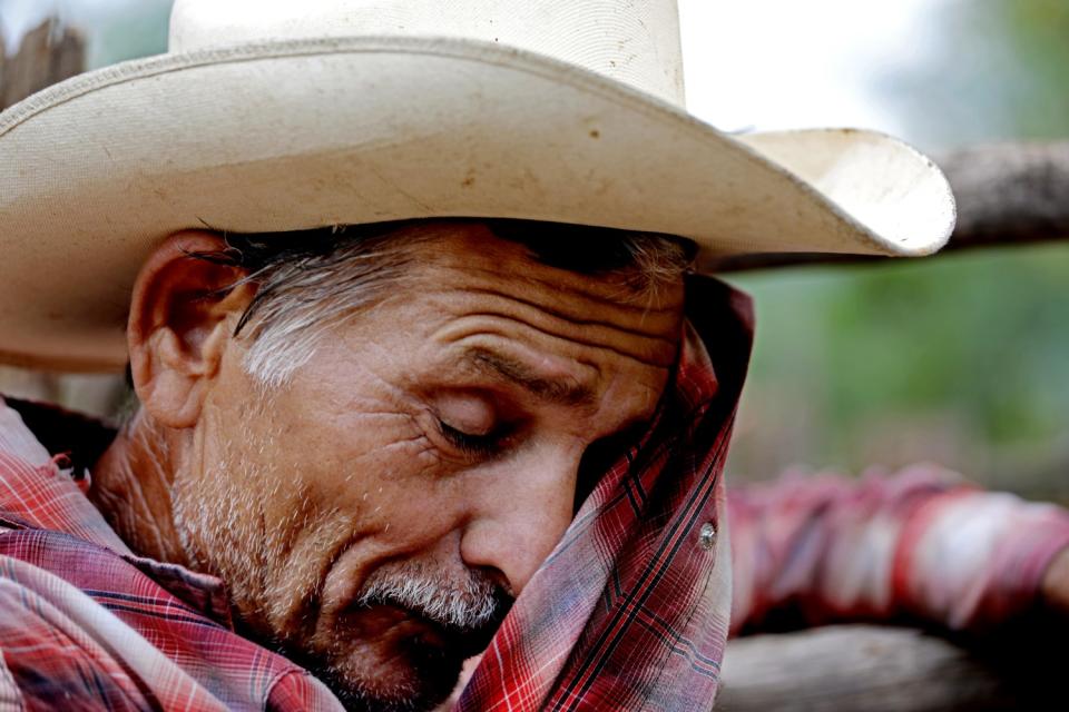 A man wipes his brow with his shirt