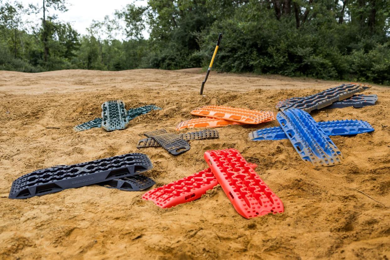 a collection of traction boards sitting on a sandy hill