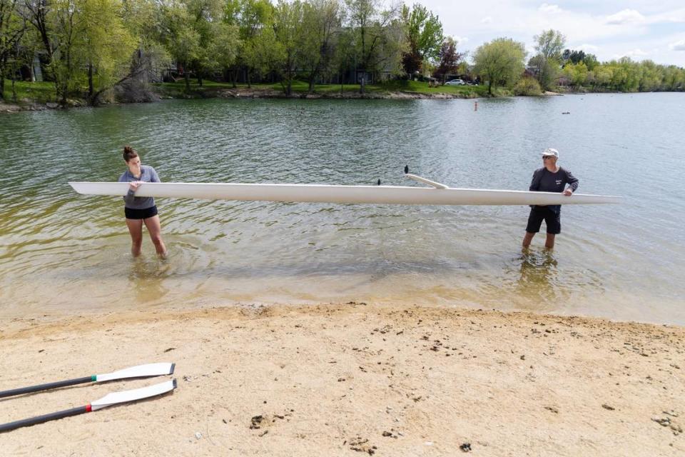 Timberline senior Cailin Bolt and her rowing coach Mike McDaniel place their 24-foot scull into Quinn’s Pond for practice.