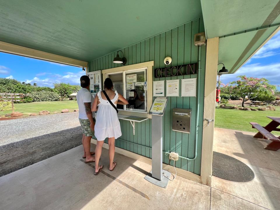 green building with two people standing at a service window