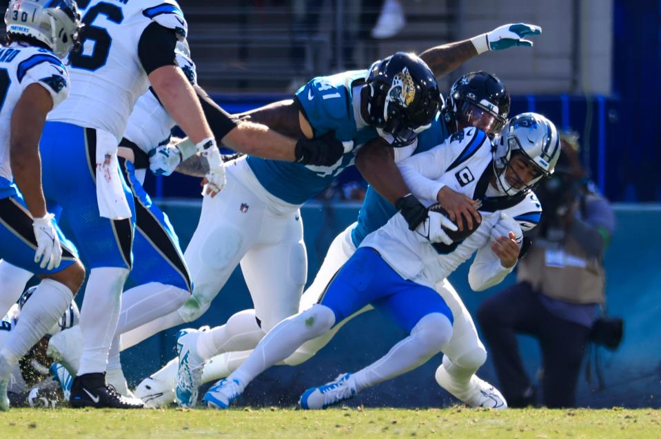 Carolina Panthers quarterback Bryce Young (9) is sacked by Jacksonville Jaguars linebacker Travon Walker (44) and as linebacker Josh Allen (41) looks on during the second quarter of a regular season NFL football matchup Sunday, Dec. 31, 2023 at EverBank Stadium in Jacksonville, Fla. The Jacksonville Jaguars blanked the Carolina Panthers 26-0. [Corey Perrine/Florida Times-Union]