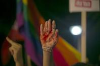 A protester holds up a glove covered in red during a protest against the violence towards the gay community in Tel Aviv August 1, 2015. REUTERS/Baz Ratner