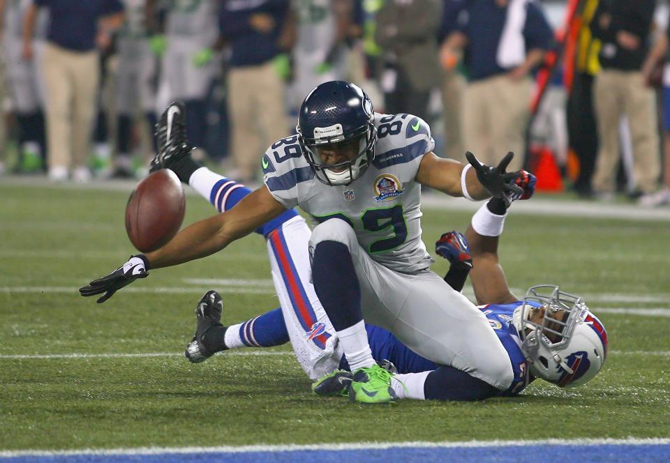 TORONTO, ON - DECEMBER 16: Doug Baldwin #89 of the Seattle Seahawks loses control of the ball after being hit by Justin Rogers #26 of the Buffalo Bills at Rogers Centre on December 16, 2012 in Toronto, Ontario.Seattle won 50-17. (Photo by Rick Stewart/Getty Images)