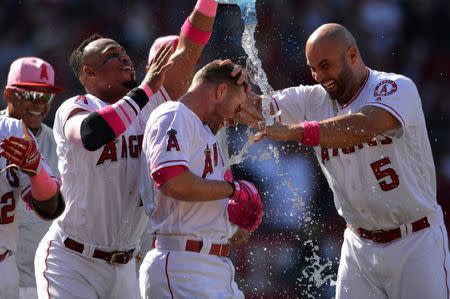 May 13, 2018; Anaheim, CA, USA; Los Angeles Angels third baseman Zack Cozart (center right) is doused with water after hitting a walk-off RBI single during the ninth inning to defeat the Minnesota Twins 2-1 at Angel Stadium of Anaheim. Mandatory Credit: Orlando Ramirez-USA TODAY Sports