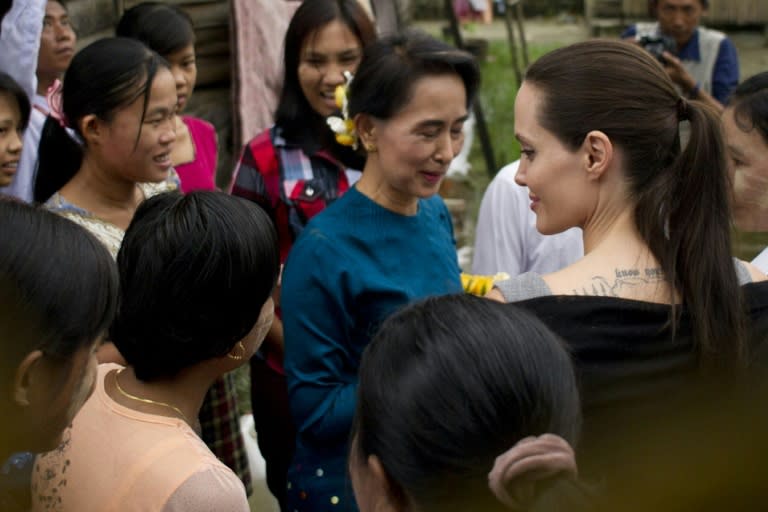 Myanmar opposition leader Aung San Suu Kyi (C) and US actress and UNHCR Goodwill Ambassador Angelina Jolie (centre, R) meet women factory workers at a hostel in Hlaing Thar Yar Township in Yangon on August 1, 2015