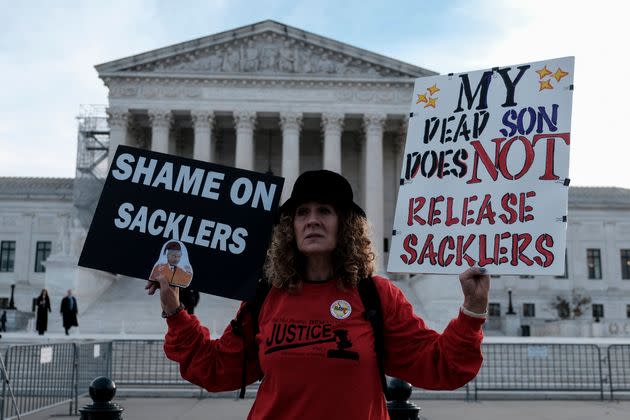 Grace Bisch hold a picture of stepson Eddie Bisch, who died of an overdose, as she protests on Dec. 4, 2023, outside the U.S. Supreme Court. The court heard oral arguments that day regarding a nationwide settlement with Purdue Pharma, manufacturer of OxyContin. The settlement aims to protect the Sackler family, which owns the company, from civil lawsuits.