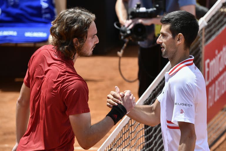 El serbio Novak Djokovic (derecha) choca las manos del griego Stefanos Tsitsipas después de ganar su partido de cuartos de final del Abierto de Italia masculino en el Foro Itálico el 15 de mayo de 2021 en Roma, Italia.