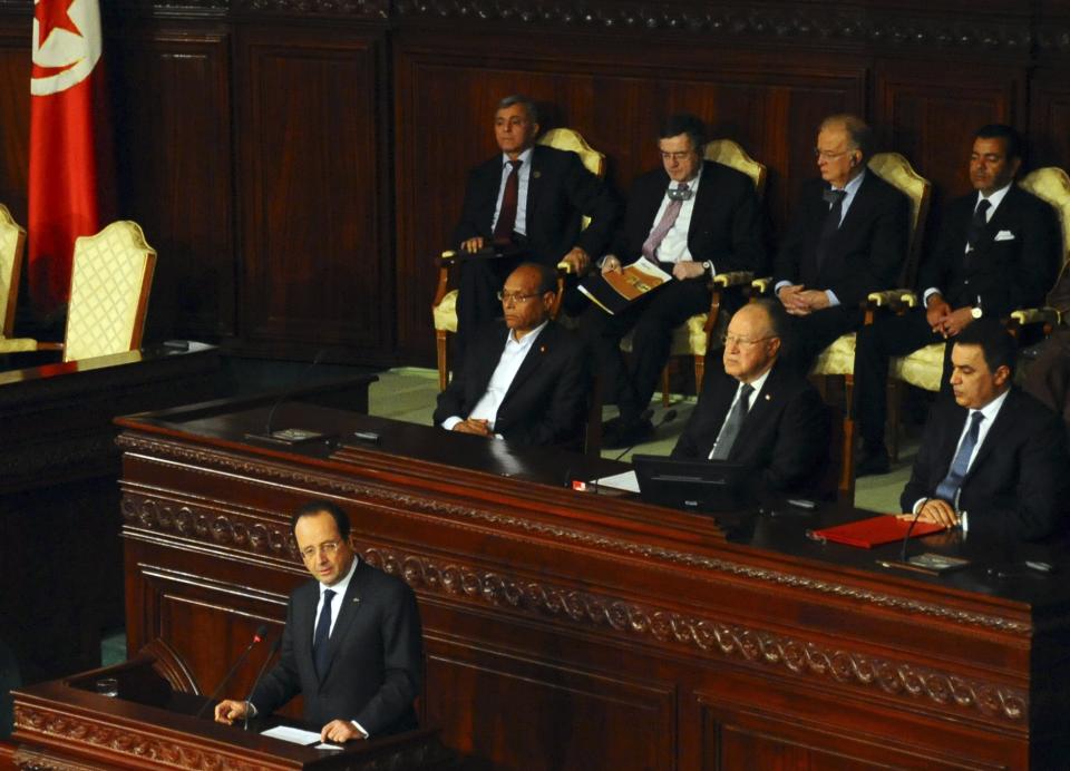 French President Francois Hollande delivers his speech, as first row, from left, Tunisian President Moncef Marzouki, Assembly speaker Mustapha Ben Jaafar, and Tunisian Prime Minister Mehdi Jomaa, listen during a ceremony at the Constituent Assembly in Tunis, Friday, Feb. 7, 2014. Hollande and other world leaders attended a ceremony for the formal adoption of a document being praised as one of the most progressive constitutions in an Arab nation. (AP Photo/Hassene Dridi)