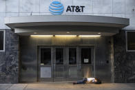 A man sleeps in front of the AT&T building in Portland, Ore., on Friday, June 4, 2021. City officials insist Portland is resilient as they launch a revitalization plan — in the form of citywide cleanups of protest damage, aggressive encampment removals, increased homeless services and police reform — to repair its reputation. (AP Photo/Paula Bronstein)