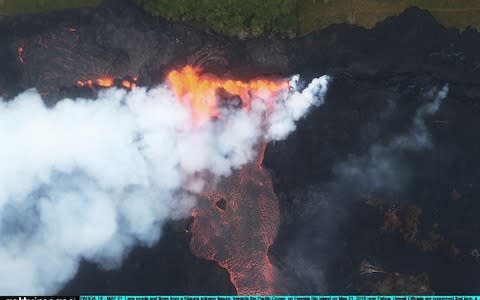 Lava erupts and flows from a Kilauea volcano fissure towards the Pacific Ocean - Credit: Getty Images