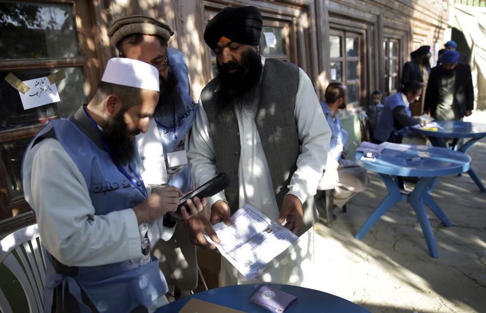 Un empleado de la comisión electoral usa un disposituvo biométrico durante las elecciones parlamentarias en Kabul, Afganistán, el sábado 20 de octubre de 2018. (AP Foto/Massoud Hossaini)