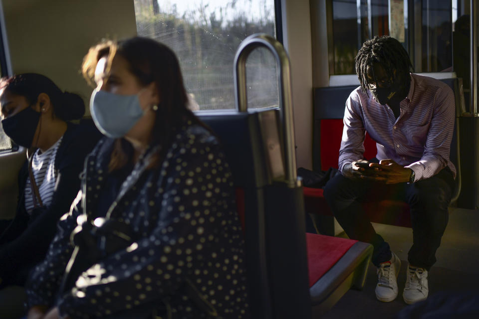 Mbaye Babacar Diouf travels on a subway, on his way to the hospital where he works, in Bilbao, northern Spain, Wednesday, Nov. 18, 2020. Mbaye Babacar Diouf's life as a migrant in Europe took a turn for the better when he was adopted in Spain at the age of 28. That enabled him to pay his debts to human traffickers, study nursing and find a job at a Spanish hospital. Now he's giving back to the community. In a Bilbao hospital he cares for COVID-19 patients. (AP Photo/Alvaro Barrientos)