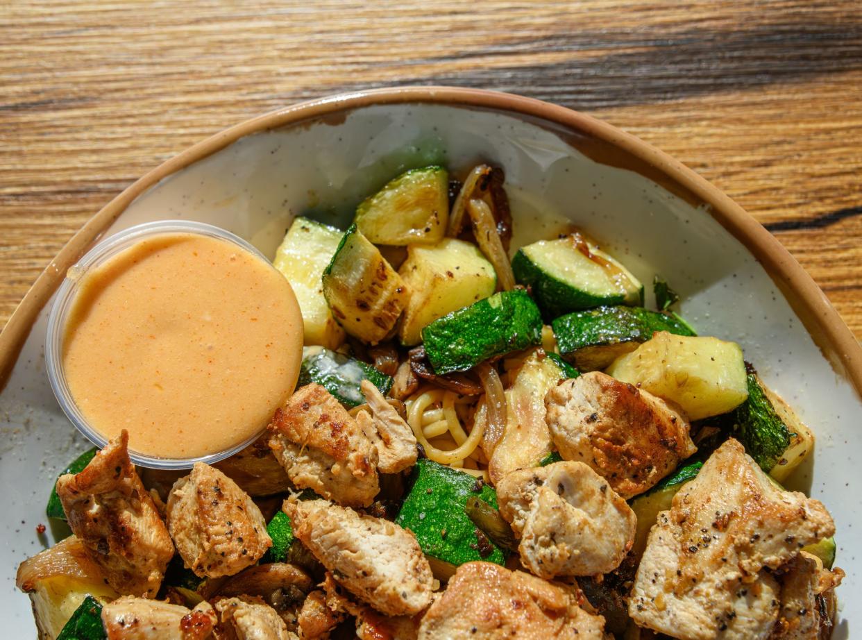 A Japanese-style hibachi chicken bowl, with noodles and vegetables.