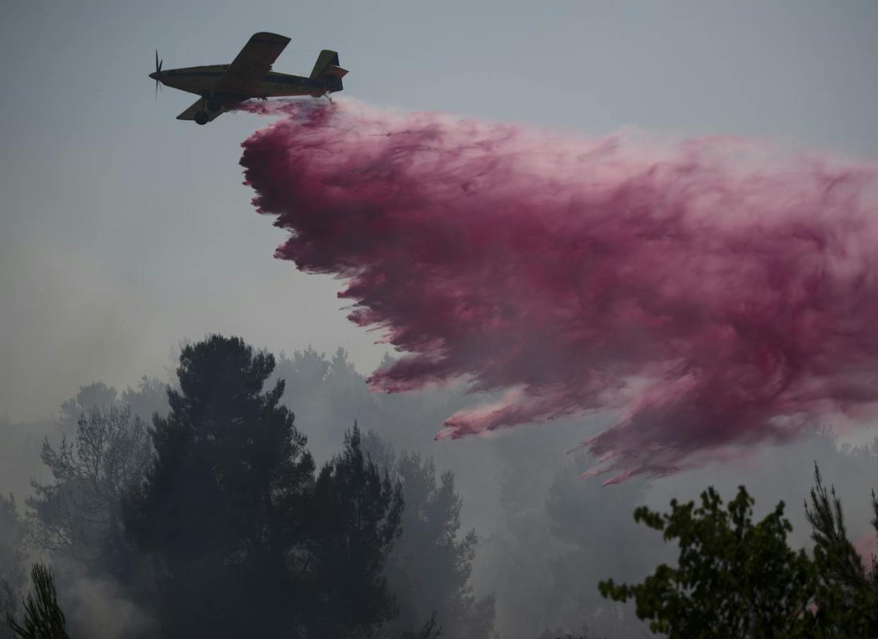 A plane uses a fire retardant to extinguish a fire near the border between Israel and Lebanon. <a href="https://newsroom.ap.org/detail/IsraelPalestiniansLebanon/da5910710a494bbc9b41a814edd2bca2/photo?Query=israel%20hezbollah&mediaType=photo&sortBy=arrivaldatetime:desc&dateRange=Anytime&totalCount=2870&currentItemNo=21" rel="nofollow noopener" target="_blank" data-ylk="slk:AP Photo/Leo Corre;elm:context_link;itc:0;sec:content-canvas" class="link ">AP Photo/Leo Corre</a>