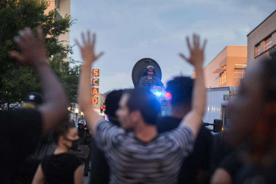 Protesters hold hands up and chant "don't shoot" during a standoff with Savannah police after a peaceful rally, Sunday, May 31, 2020, over the death of George Floyd in Minneapolis. (Stephen B. Morton/Atlanta Journal-Constitution via AP)