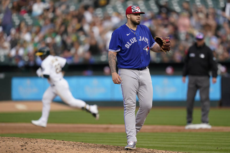 Toronto Blue Jays pitcher Alek Manoah, right, reacts as Oakland Athletics' Ramon Laureano, left, rounds the bases after hitting a home run during the fifth inning of a baseball game in Oakland, Calif., Monday, July 4, 2022. (AP Photo/Jeff Chiu)