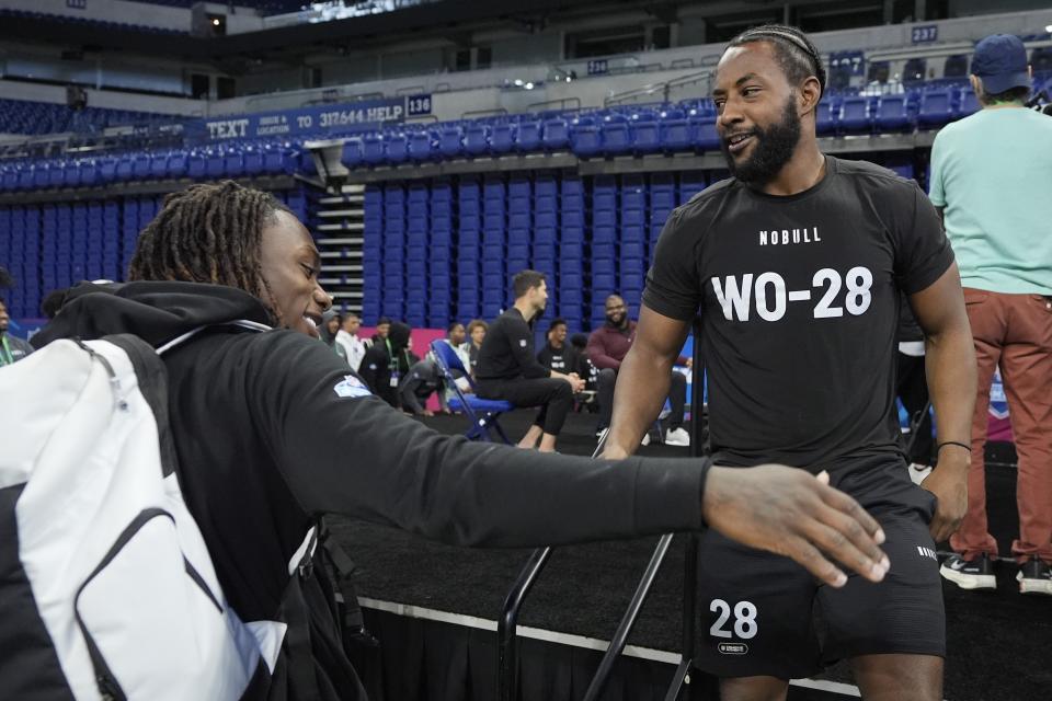 Texas A&M wide receiver Ainias Smith, right, reacts with Texas wide receiver Xavier Worthy after he participated in the bench press at the NFL football scouting combine, Sunday, March 3, 2024, in Indianapolis. (AP Photo/Darron Cummings)